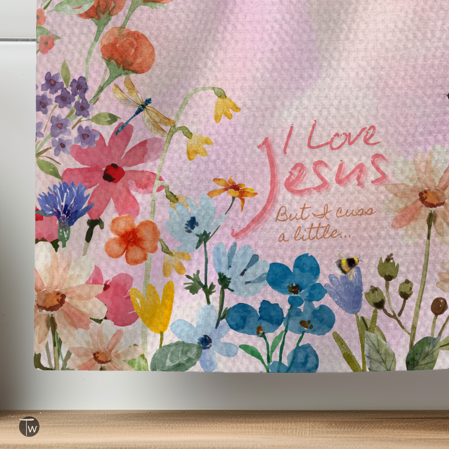 I Love Jesus but I cuss a little towel featuring colorful floral designs on a textured background.