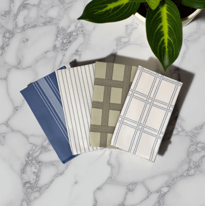 Shitshow plaid towel in retro colors, featuring blue, green, and beige patterns on a marble surface.
