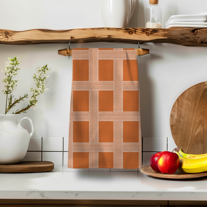 Vintage Shitshow Fall Edition towel in orange with a grid pattern, displayed on a wooden shelf with apples and bananas.