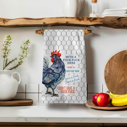 Perfect Towel™ featuring a blue rooster design with humorous text, hanging on a wooden rack in a kitchen setting.