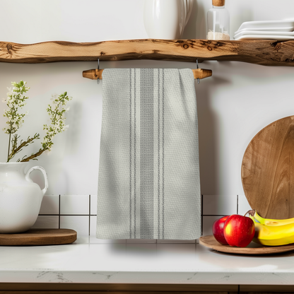 Pardon My French Stripe Illusion towel hanging on a wooden shelf with apples and bananas in the foreground.