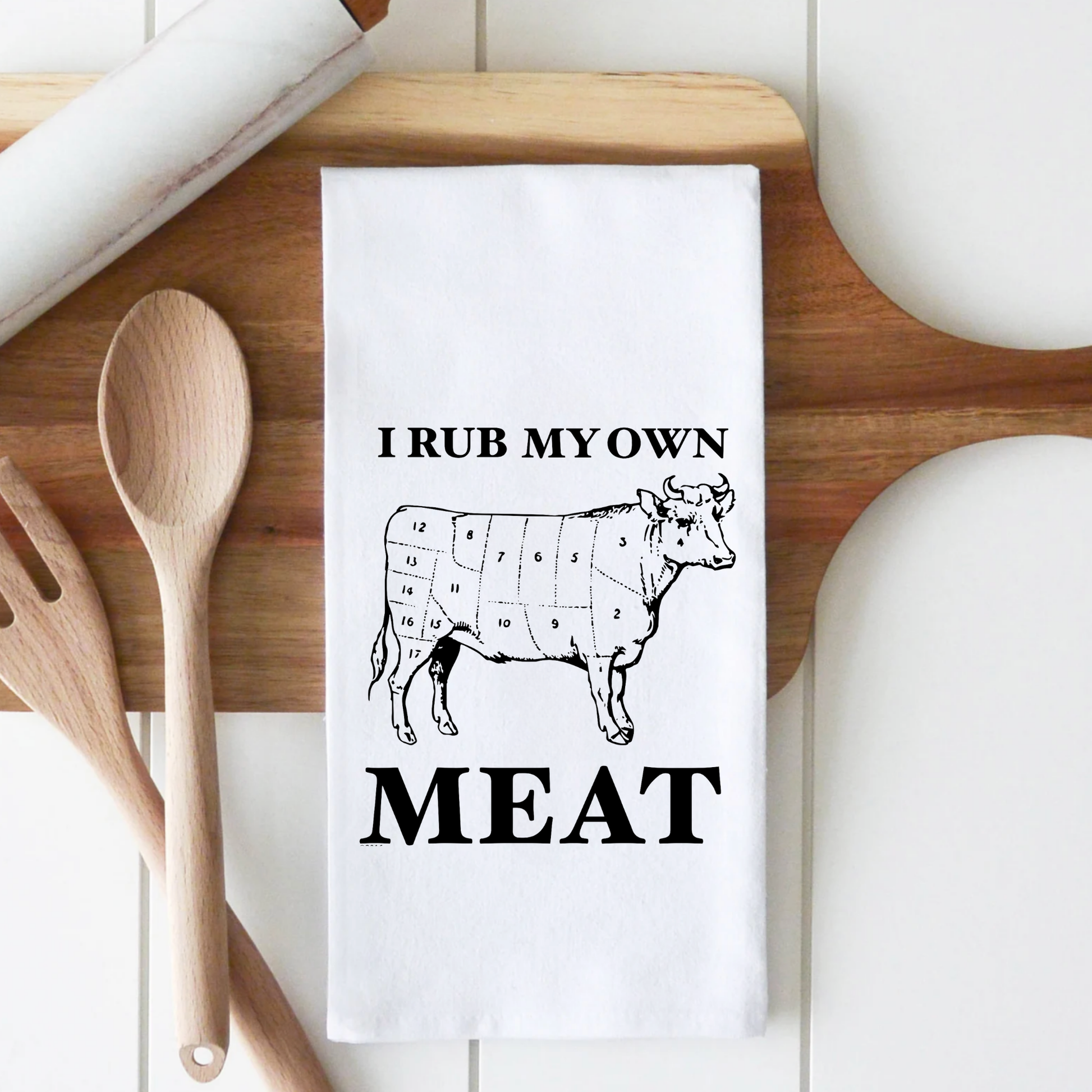 White cotton tea towel featuring a cow illustration with the text "I rub my own meat" in bold black letters.