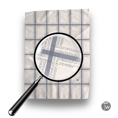 Fresh Out Plaid Illusion kitchen tea towel in cream with blue plaid pattern and text design.