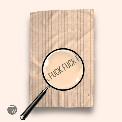 Colette Stripe Fall Edition towel in beige with subtle stripes, magnifying glass highlighting text on the fabric.