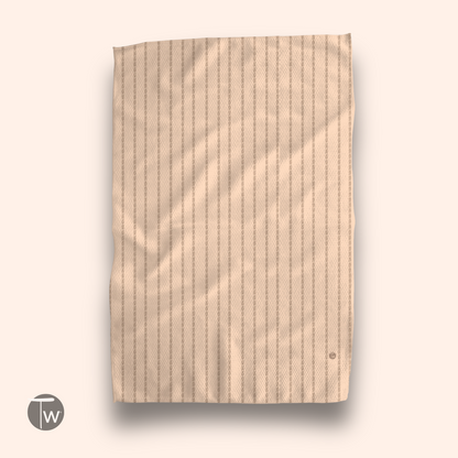 Colette Stripe Fall Edition towel in soft beige with vertical stripes, featuring a subtle logo in the corner.