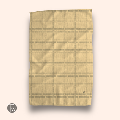 F-ity plaid illusion towel in a warm yellow color with a textured grid pattern, featuring a small logo at the bottom.