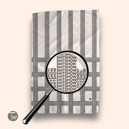 Vintage classic design kitchen tea towel featuring the word "SHITSHOW" in a repeated pattern on a neutral background.