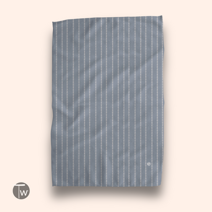 Colette Stripe Illusion towel in light blue with white stripes, displayed flat against a soft background.