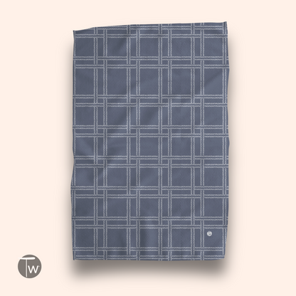 Blue plaid illusion kitchen towel featuring a white grid pattern, displayed flat against a light background.