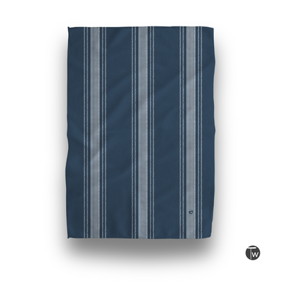 Dark blue towel featuring French stripe design in lighter shades, displayed flat with a textured surface.