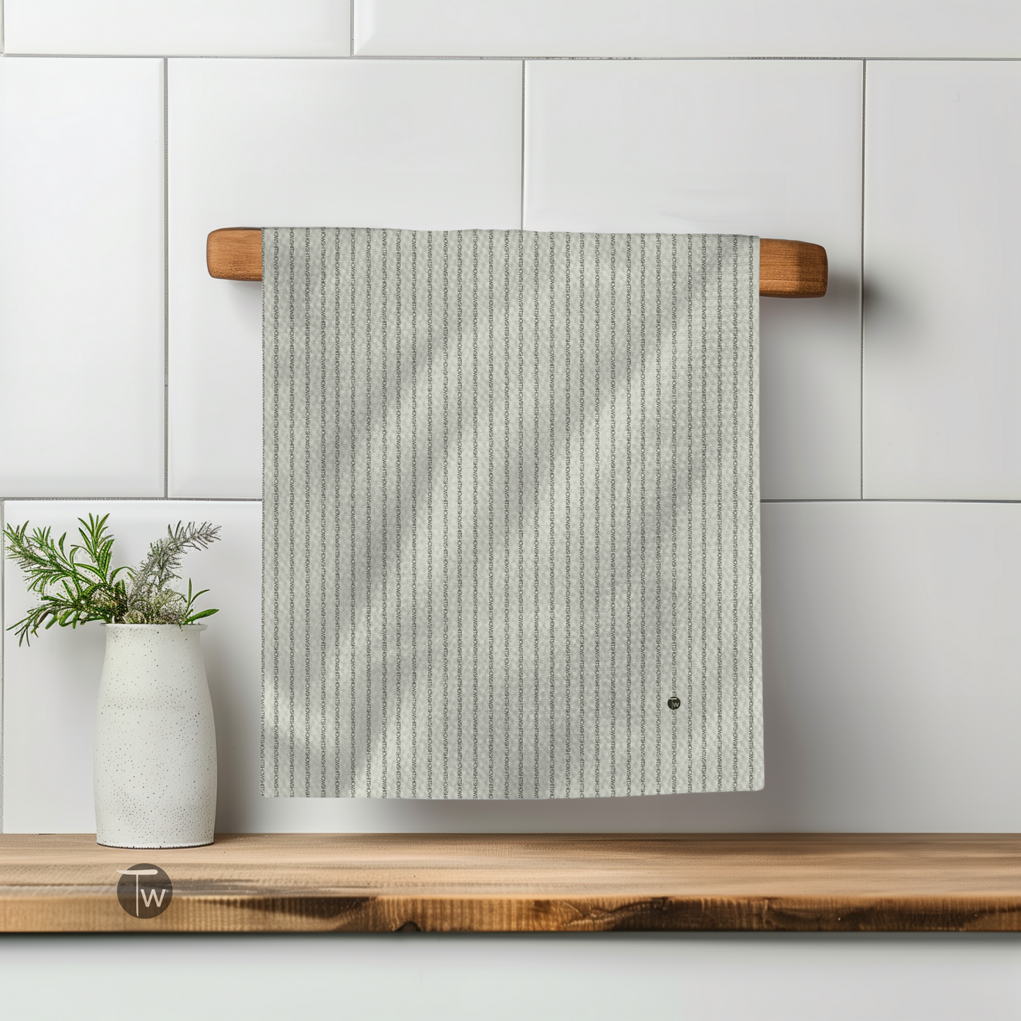 Shitshow in Colette stripes perfect towel hanging on a wooden rack with a vase and plant in the background.