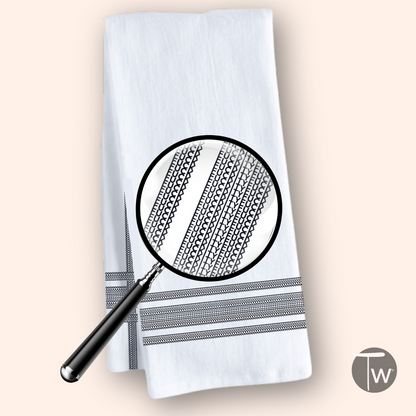 Fckity Stripe Illusion black cotton tea towel with striped pattern and magnifying glass detail.