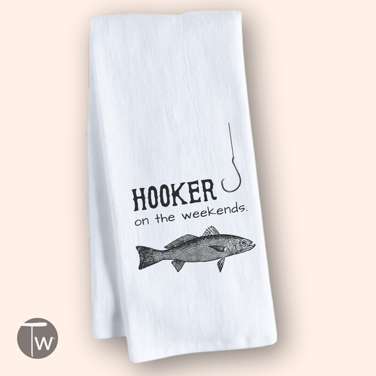 White cotton tea towel featuring the text "Hooker on the weekends" and an illustration of a fish and fishing hook.