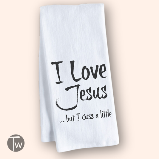 White cotton tea towel featuring the text "I Love Jesus but I cuss a little" in black font.