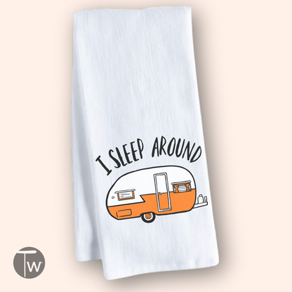 White cotton tea towel featuring an orange retro camper illustration and the text "I sleep around.