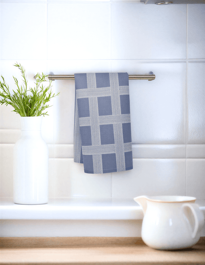 Vintage Shitshow classic illusion kitchen tea towel in gray and white, hanging on a metal rack with a plant nearby.